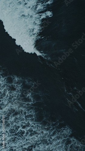 Φωτογραφία Powerful ocean swell with dramatic cloudy sky / TOPDOWN DRONE