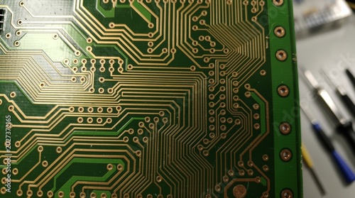 Detailed close-up of a complex green circuit board with golden traces
