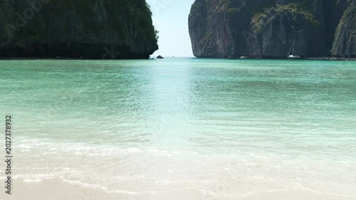 Serene Tropical Beach with Turquoise Water and Lush Cliffs Creates Tranquil Paradise Evoking Tranquility