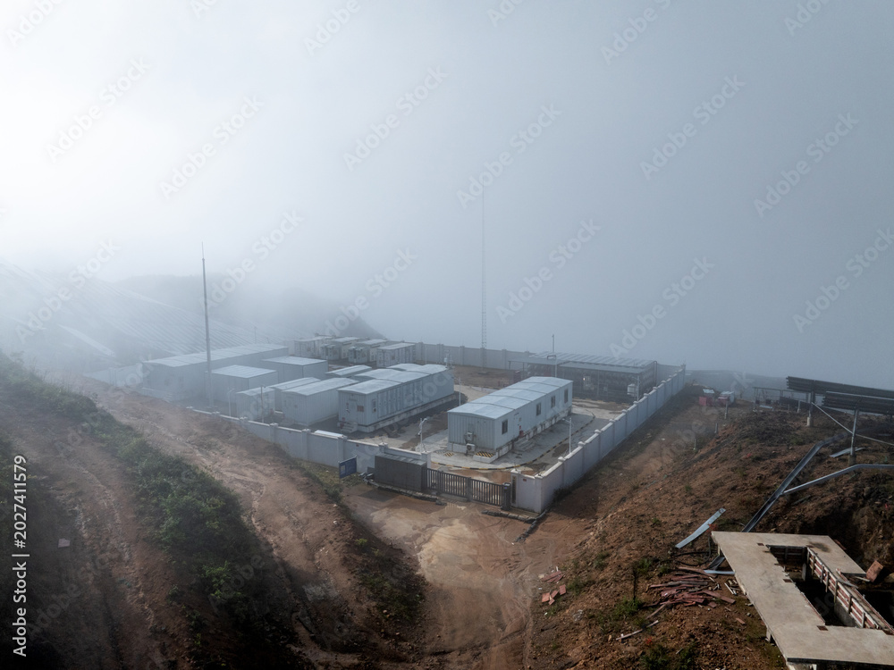 Fototapeta premium white container houses built on a mountain top shrouded in thick fog and mist