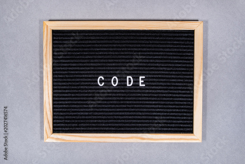 schwarze Buchstabentafel mit Codetext