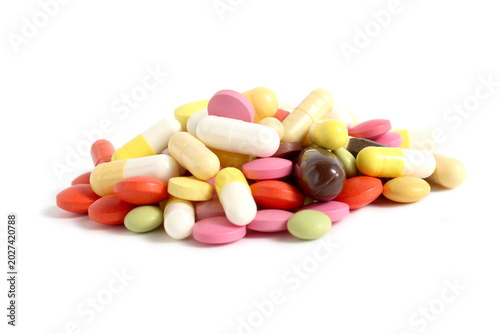 There is a pile of brightly colored pills on a white background.