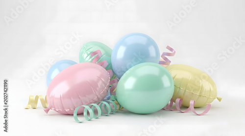Pastel colored foil balloons in pink blue and yellow with matching curly ribbons on a plain white studio background
