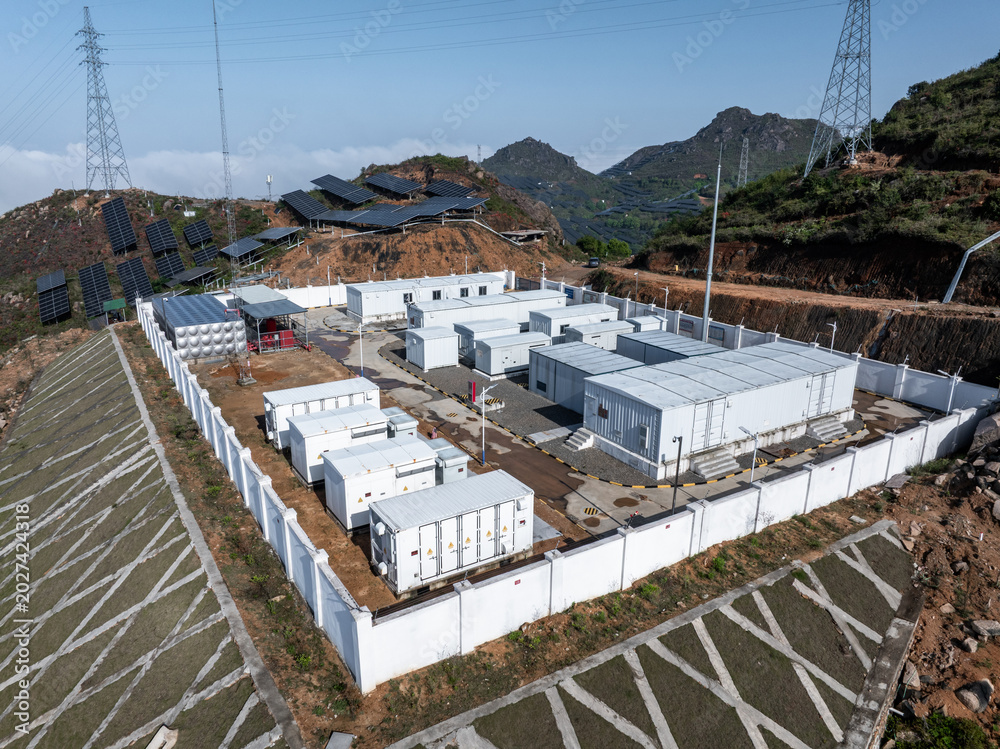 Fototapeta premium Energy storage container facility at a mountain photovoltaic power station with solar panels