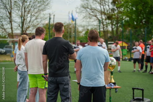 Foto Soccer team gathered on the field with a trophy table in front of them outdoors, championship celebration moment, sports success concept