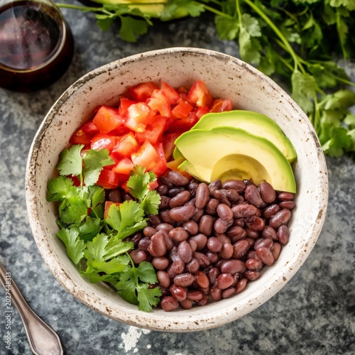 Fresh Salad Bowl With Black Beans, Avocado, Tomato, and Cilantro on a Colorfu...