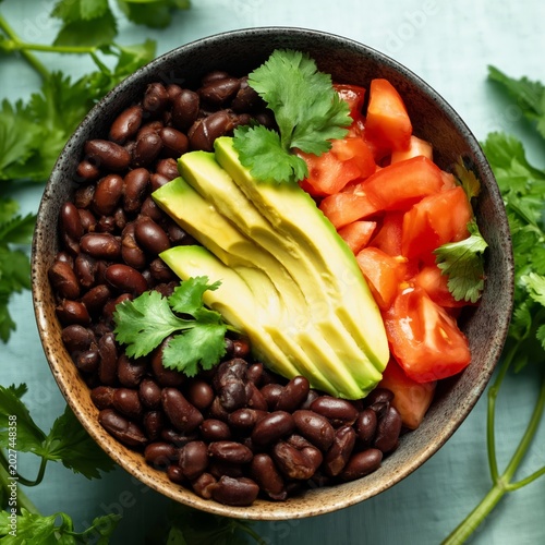 Black Beans, Avocado, Tomatoes, and Cilantro in a Bowl on a Blue Table