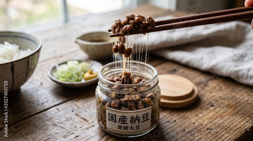 Sticky Fermented Natto Soybeans Lifted with Chopsticks from Jar Japanese Food Culture