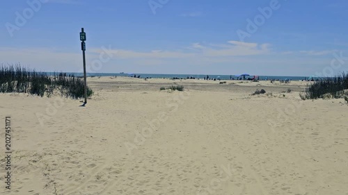  First person view (FPV)-Walking in sand-Approaching beach- Sullivan Island, SC already lined with sun seeking beach goers on one of the first warm spring days of the coming summer vacation season