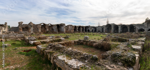 Ruins of a historic Seljuk caravanserai standing within the Mediterranean countryside of Antalya, Türkiye, reflecting the architectural heritage of ancient Anatolian trade routes.