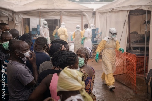 Urgent vigilance: People await care outside Ebola facility; medics in full PPE