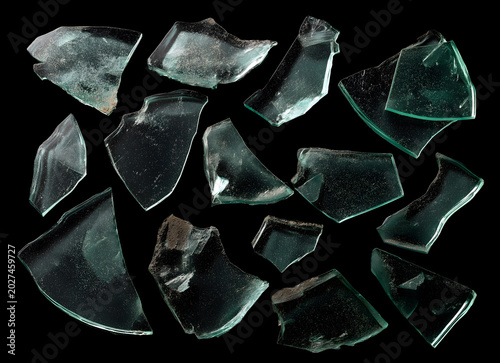 Collection of broken green glass shards isolated on a black background