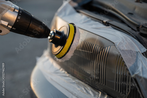 Obraz na plátně The process of polishing car headlights outdoors.