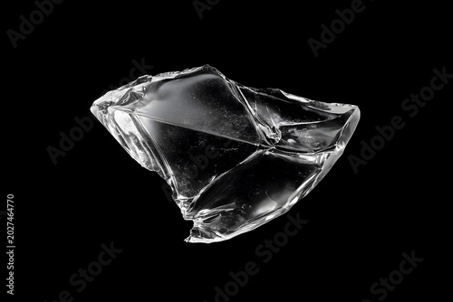 Transparent Shard of Broken Glass or Crystal with Sharp Facets Isolated on a Black Background