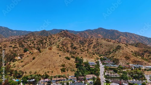 Heading to the bare rocks with scarce vegetation. Drone footage over the residential neighborhoods in Los Angeles, California, USA.