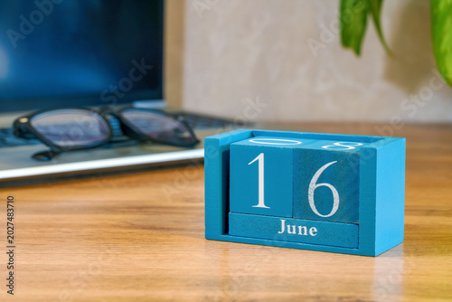Fotografie Desktop calendar made of wooden blocks displaying June 16 on table