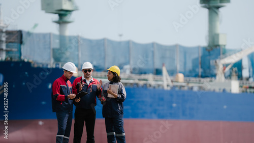 Happy team professional engineer, worker, technician use clipboard discuss work, walk in steel metal manufacture factory plant industry. engineer at commercial shipping port terminal