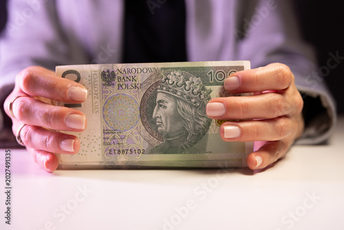 Foto kobieta trzyma w dłoniach banknot 100 zł