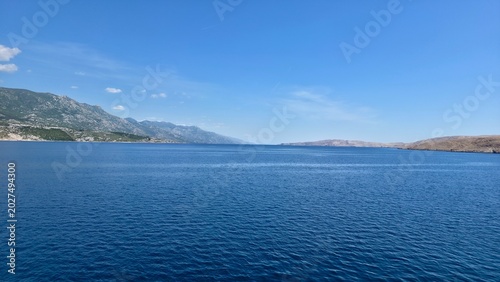 Bild auf Leinwand Horizontal view of the open sea surface and the passage between two landmasses