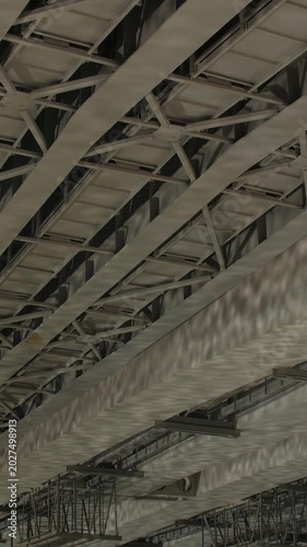 Metal beams of a bridge with water ripple light reflections underneath