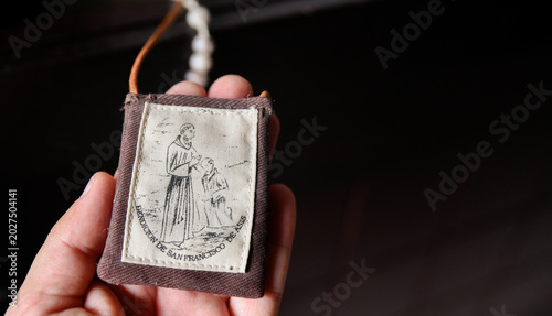 Fotografie Hand holding Franciscan Catholic devotional scapular