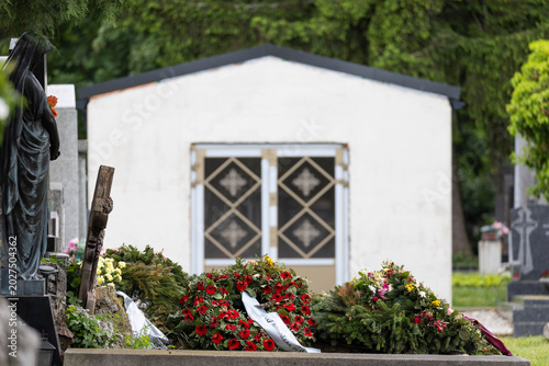 Cuadro en lienzo Grab mit Blumen Kränzen am Friedhof