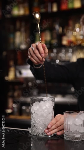 A skilled bartender expertly crafts a fresh cocktail behind a stylish bar counter