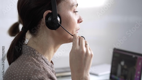Photos Focused female call center operator in brawn dotted blouse is assisting clients online, providing customer support and answering inquiries