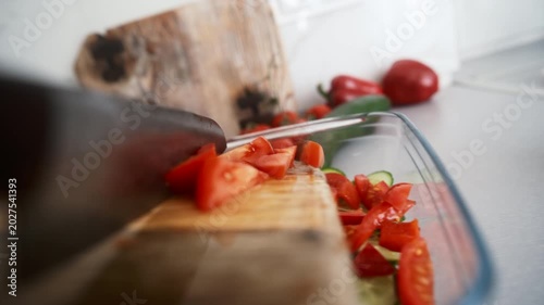 Chef Knife Drops Chopped Tomatoes Into A Greek Salad From A Wooden Cutting Board In The Kitchen, Object POV camera angle shot