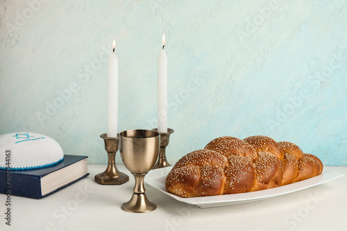 Schilderij op canvas Traditional challah bread with goblet for wine and burning candles on white table