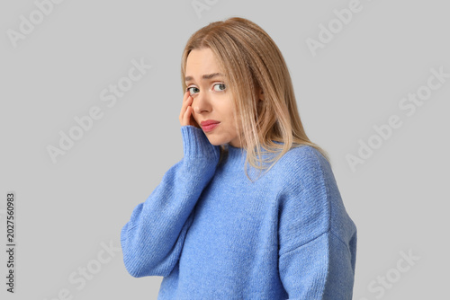 Fotografía Embarrassed young woman on grey background