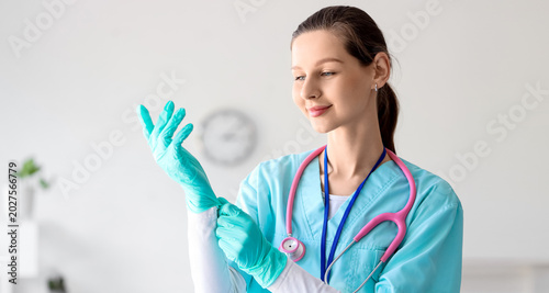 Female medical intern with gloves in clinic
