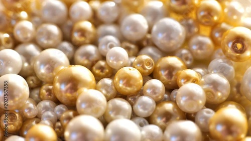 Artificial pearls.Beads Background. Materials for crafts, sewing, embroidery, and jewelry making. Mother-of-pearl beads in white and golden tones