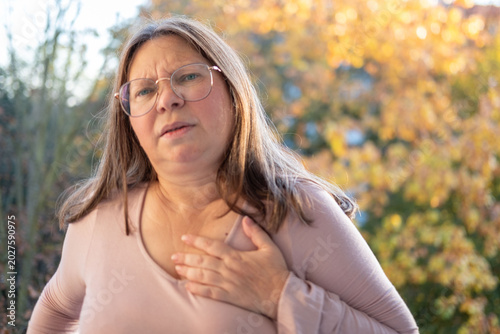 Konstfotografi Middle-aged woman experiencing chest pain, pressing hands to heart