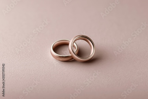Minimalist flat design World Marriage Day illustration with golden ring silhouettes forming heart shape on pale blush background