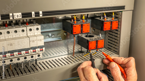 Fotografie Electrical contractor engineer testing current transformers in an HVAC control cabinet
