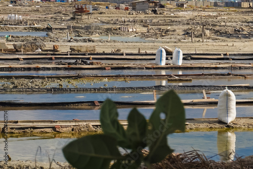 Salt pans stretch across a sunlit, dry landscape