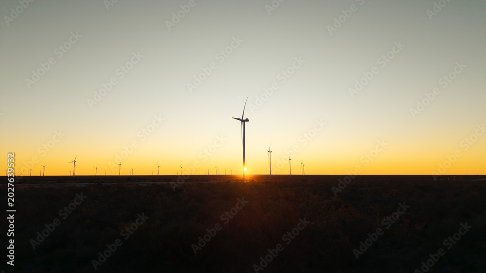 Obraz premium Wind farm at sunset symbolizing clean energy transition and sustainable industrial development.