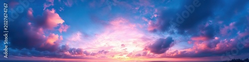 Panoramic vibrant pink and purple clouds over a calm ocean horizon at sunrise, a serene and awe-inspiring sky