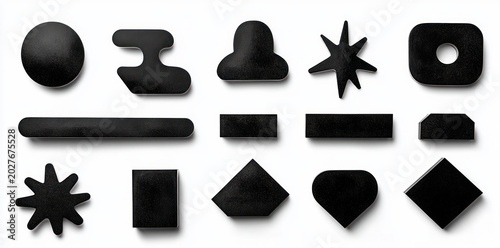 Assorted matte black geometric and abstract shapes including circle, bars, rectangles, stars, diamond, heart and hole-punched rounded square in a minimalist playful layout with soft shadows