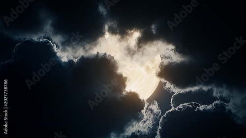 Golden moon peers through stormy clouds