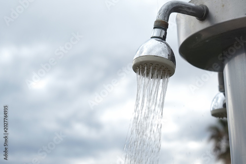 Photos Water flows from a showerhead in an outdoor setting