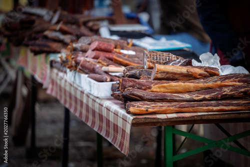 Pecenica, slanina, and dried meat called suvo meso and other Serbian cured meat displayed on a market stand, showing traditional pork products and Balkan food culture in Serbia.
