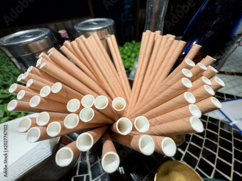 Fotografija Kraft paper straws displayed on a bar counter, showing a cardboard alternative to plastic straws in food service and beverage settings