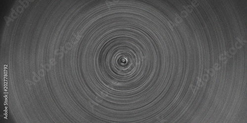 Abstract radial blur effect in grayscale with concentric circles creating a sense of deep vortex or spin.
