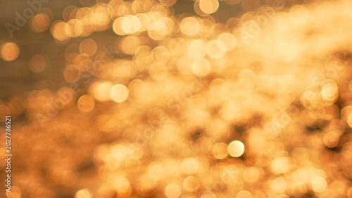 Obraz na płótnie Bokeh light abstract, shimmering golden reflections on water, creating a beautif