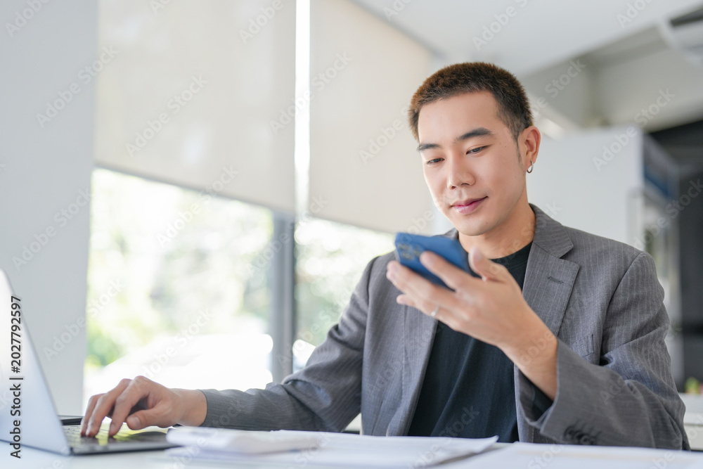 Fototapeta premium Young Business man holding Smartphone&nbsp;working mobile devices. cell telephone technology e-commerce smartphone for business work