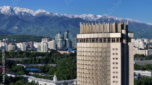 A quadcopter aerial view of the central part of Almaty, Kazakhstan, on a spring morning, with a mountain range in the background.