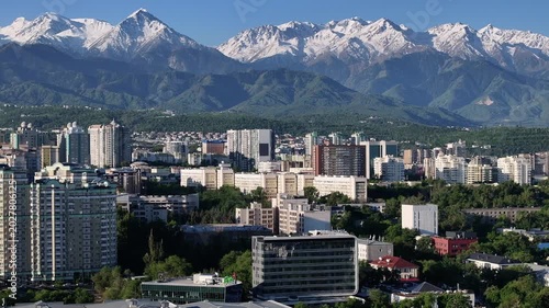 A quadcopter aerial view of the central part of Almaty, Kazakhstan, on a spring morning, with a mountain range in the background.