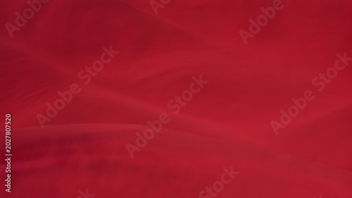 Sweeping undulations of red desert sand dunes forming a smooth natural landscape